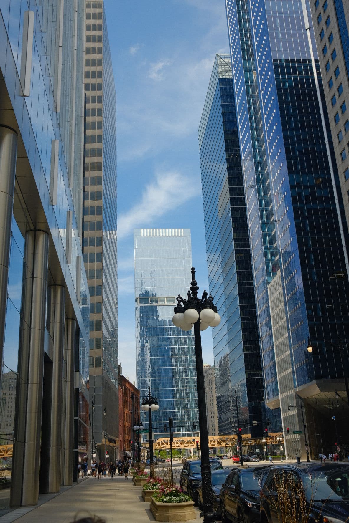 Chicago street lined with glass towers and an old lamppost