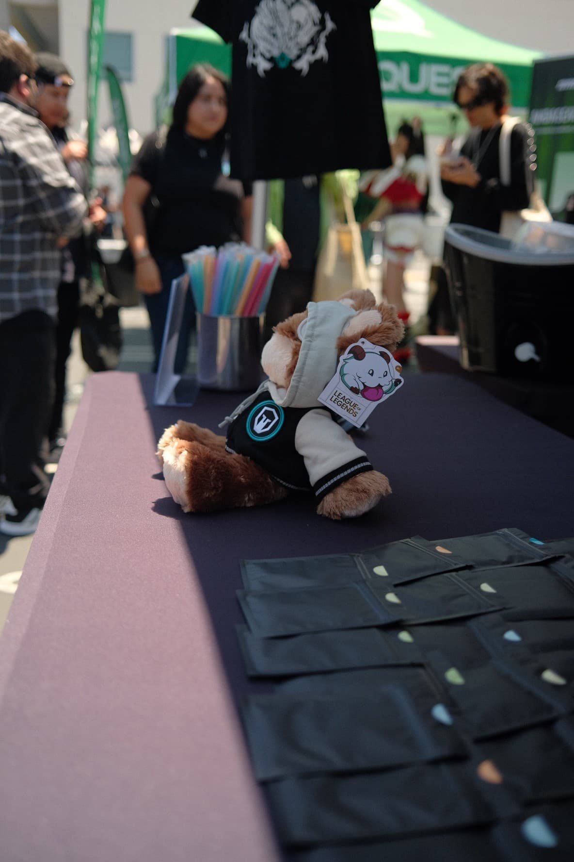 A League of Legends Poro plush in an Immortals jacket on an event table