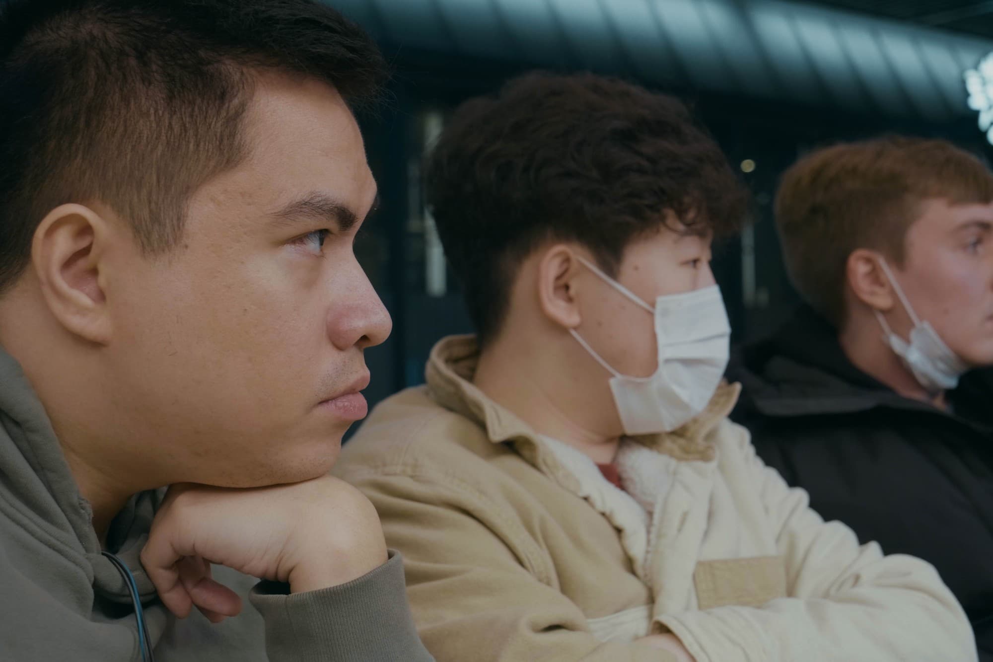 Three people in profile watching something off camera
